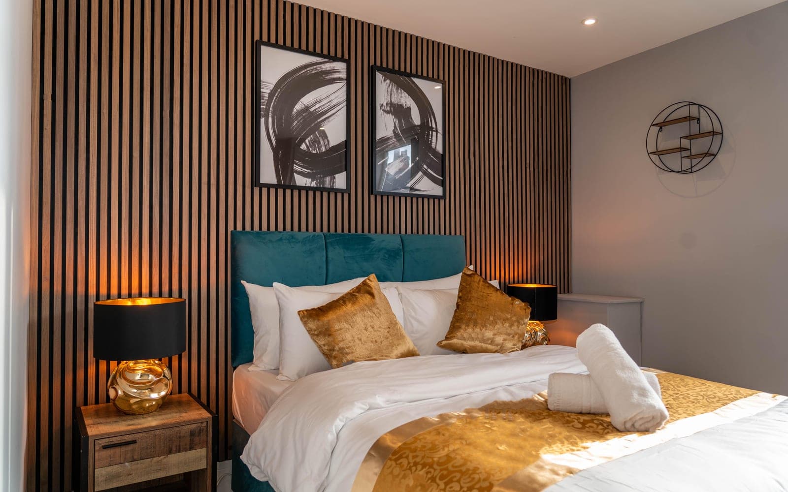 Living room with a teal velvet sofa and gold wall art at Saint Clement's Street, Oxford