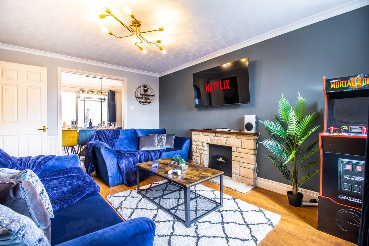 Lounge with blue velvet sofas and an arcade machine