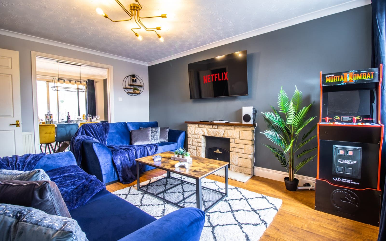 Lounge with blue velvet sofas and an arcade machine at Tyrrel Way, Stoke