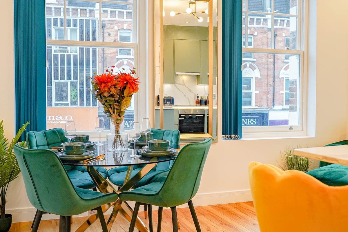 Living room with a green velvet sofa and tall windows
