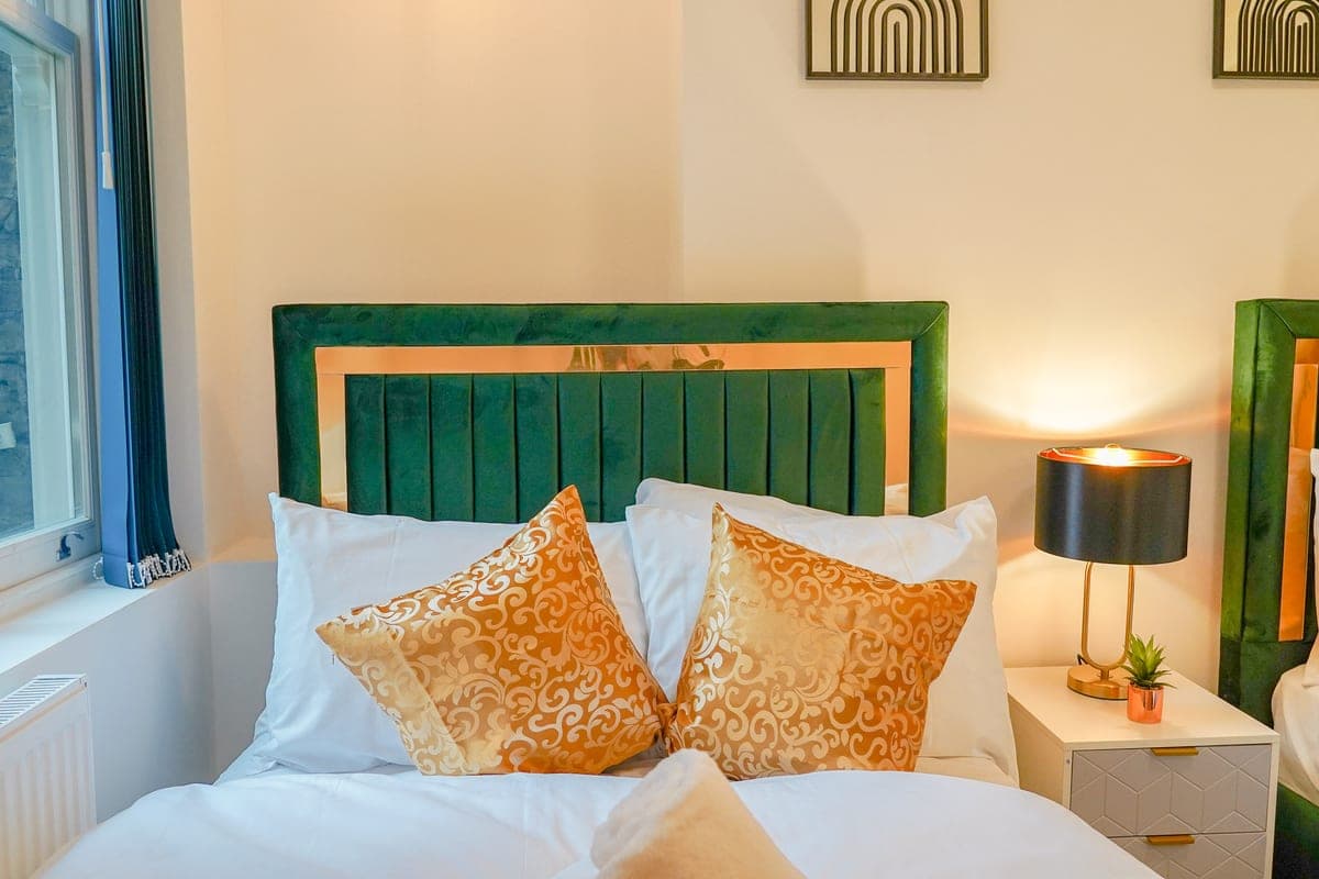 Double bedroom with a green velvet headboard